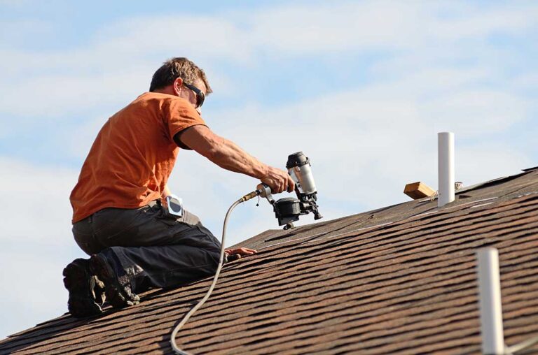 Light-colored residential roof reflecting sunlight above a ventilated attic during summer.